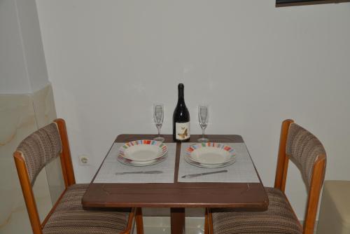 a dining room table with a bottle of wine and glasses at Tonia Apartments Kontogialos in Pelekas