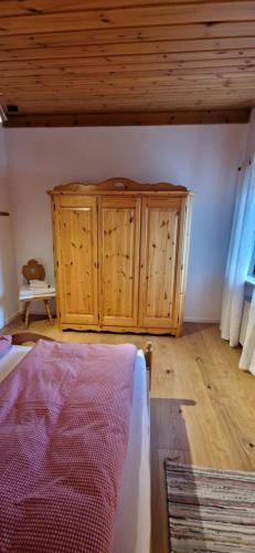 a bedroom with wooden cabinets and a bed in a room at Chalet Chiemgau 90 qm 3 Zimmer Balkon in Übersee