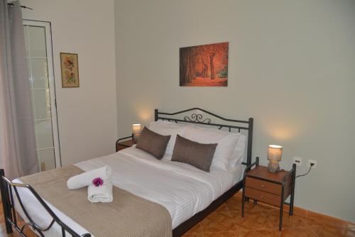 a bedroom with a bed and a table with two chairs at Tonia Apartments Kontogialos in Pelekas
