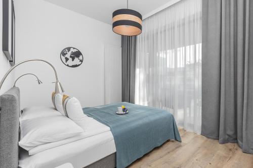 a bedroom with a bed with a blue blanket and a table at Apartament Relax Rogowo Balkon & Parking by Noclegi Renters in Rogowo
