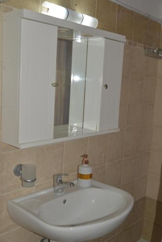 a bathroom sink with a medicine cabinet and a mirror at Tonia Apartments Kontogialos in Pelekas