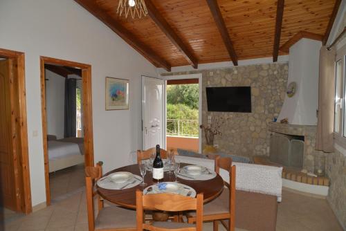 a dining room with a table and a living room at Tonia Apartments Kontogialos in Pelekas