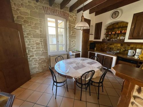 une cuisine avec une table et des chaises dans une pièce dans l'établissement Charmante maison de campagne à Bren, à Bren