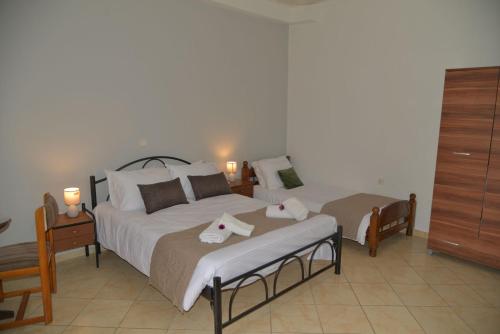 a bedroom with two beds with towels on them at Tonia Apartments Kontogialos in Pelekas
