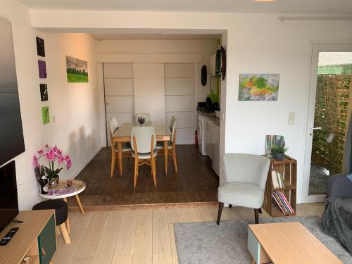 un salon avec une table et une cuisine dans l'établissement Le Petit Breizh, gîtes culturel Aux Petits Bonheur, à Férel