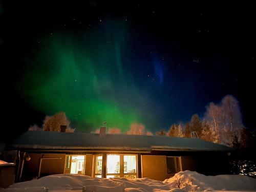 una casa con la aurora en el cielo en Arctic Riverside house, en Rovaniemi