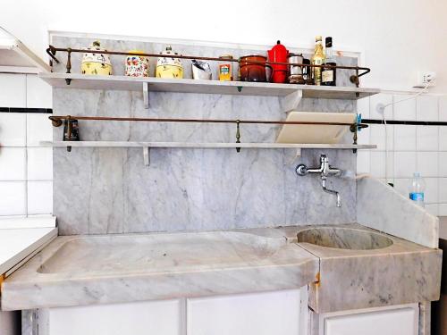 a kitchen with a sink and shelves on the wall at Villino a 20 metri dal mare in Levanto