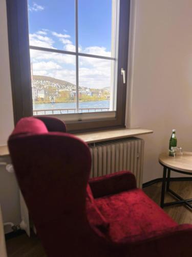 a living room with two chairs and a window at Moselhotel Römischer Kaiser in Bernkastel-Kues