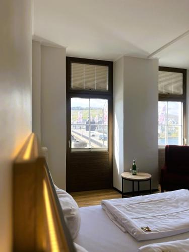 a bedroom with a bed and a window and a door at Moselhotel Römischer Kaiser in Bernkastel-Kues
