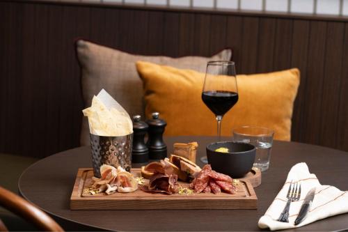 a table with a plate of food and a glass of wine at Brussels Marriott Hotel Grand Place in Brussels
