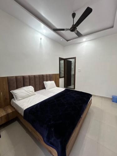 a bed in a room with a ceiling fan at Madhav Guest House in Mathura