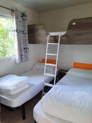 une chambre avec deux lits superposés et une échelle dans l'établissement Camping de Salviac, à Salviac