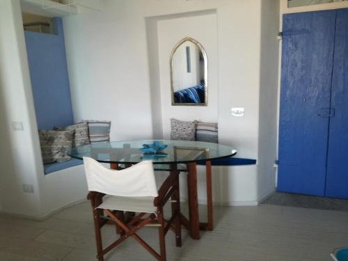 a dining room with a glass table and two white chairs at Occhio sul mare in Isola del Giglio