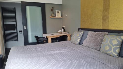 a bedroom with a bed and a desk with a table at Bed & Breakfast De Schans in Makkum