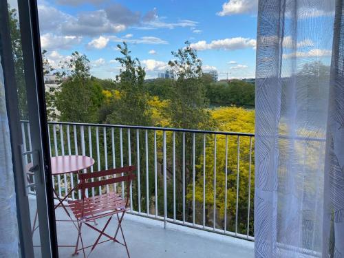 d'un balcon avec une chaise, une table et une vue. dans l'établissement Appartement chaleureux Belle vue Proche de Paris, à Boulogne-Billancourt