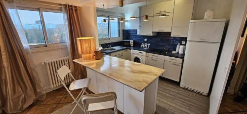 une cuisine avec un réfrigérateur blanc et un comptoir dans l'établissement Appartement chaleureux Belle vue Proche de Paris, à Boulogne-Billancourt