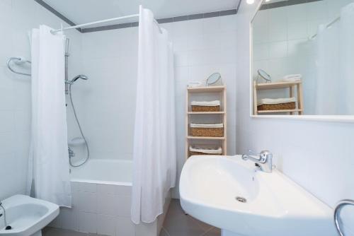 ein weißes Badezimmer mit Waschbecken und Dusche in der Unterkunft Can Roig -Caldes- in Colònia de Sant Pere