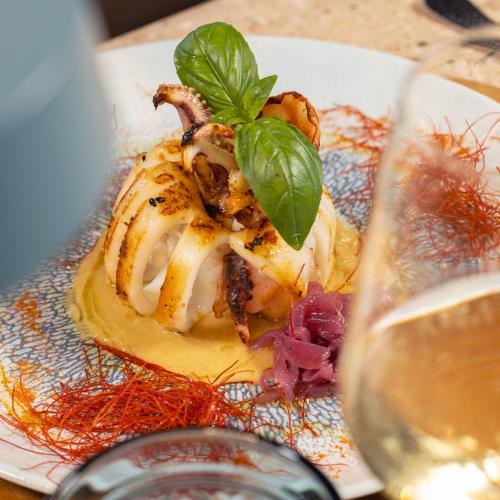 a plate of food on a table with a glass of wine at Selinunte Boutique Hotel in Marinella di Selinunte