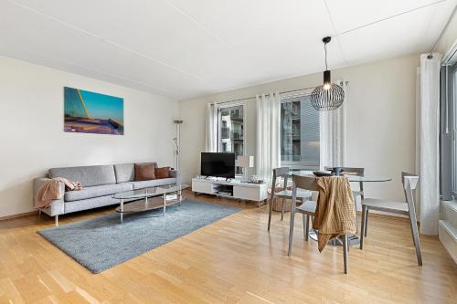 a living room with a couch and a table at BJØRVIKA APARTMENTS, Teaterplassen, Oslo city center in Oslo