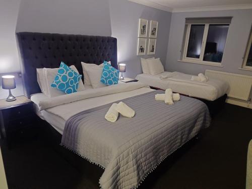two beds in a hotel room with towels on them at Dancenter Birmingham Airport near NEC in Kenilworth