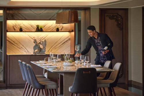 a man standing in front of a table with wine glasses at The Westin Resort Nusa Dua, Bali in Nusa Dua