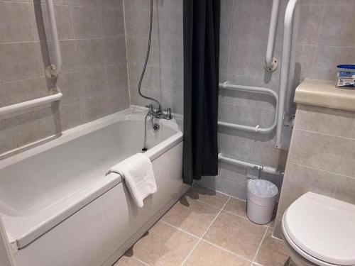 a bathroom with a white tub and a toilet at Dancenter East Midlands Airport in Derby