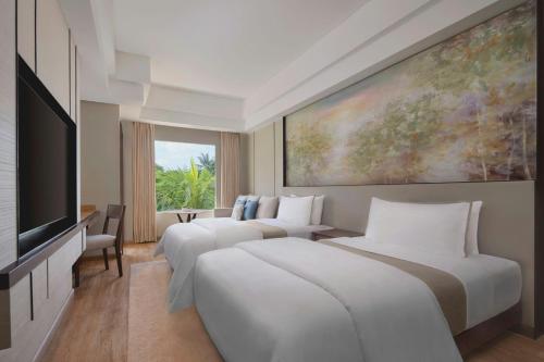 a hotel room with three beds and a flat screen tv at The Westin Resort Nusa Dua, Bali in Nusa Dua