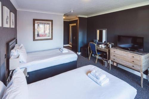 a hotel room with two beds and a desk at Dancenter Birmingham Airport near NEC in Kenilworth
