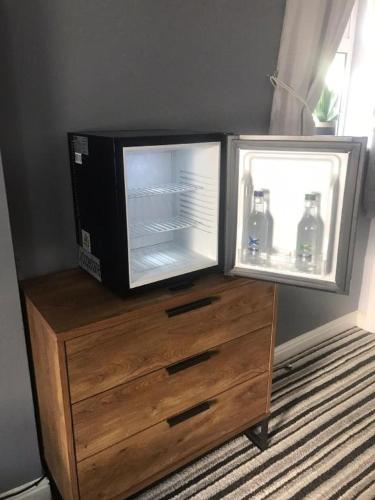 a microwave on top of a wooden dresser with a refrigerator at Dancenter East Midlands Airport in Derby