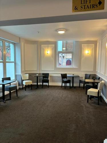 a waiting room with tables and chairs and windows at Dancenter East Midlands Airport in Derby