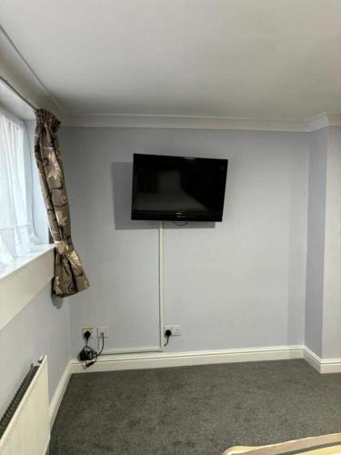 a living room with a flat screen tv on the wall at Dancenter East Midlands Airport in Derby