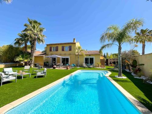 une piscine devant une maison dans l'établissement Maison spacieuse avec piscine à Sanary-sur-Mer, à Sanary-sur-Mer