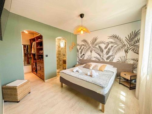 - une chambre avec un lit orné d'une fresque murale de palmiers dans l'établissement Maison spacieuse avec piscine à Sanary-sur-Mer, à Sanary-sur-Mer