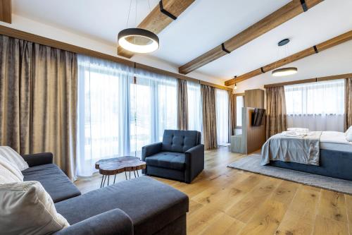 a bedroom with a bed and a couch and a chair at Penzion Včelařský Dvůr in Lednice