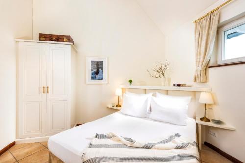 a bedroom with a white bed with white pillows at Precise Resort Schwielowsee - Apartments in Werder