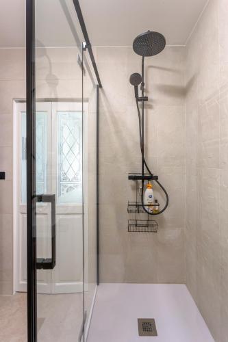 une douche avec une porte vitrée dans une salle de bain dans l'établissement Chez Martin - Spacieux appartement climatisé proche de la plage, à La Grande Motte