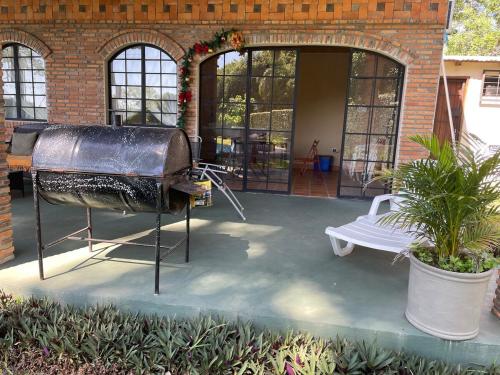 a grill in front of a building with a patio at Colonial-style house in Villarrica