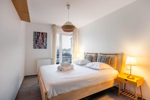 une chambre avec un lit avec des draps blancs et une fenêtre dans l'établissement Le Secret de Vallin - Proche centre Nancy, à Nancy