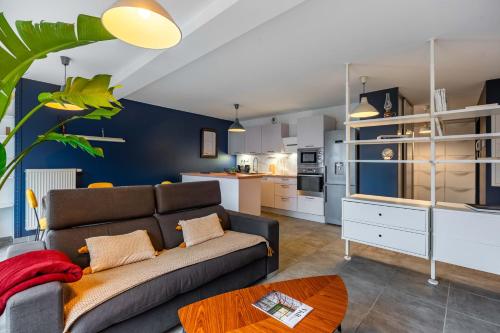 un salon avec un canapé et une cuisine dans l'établissement Le Secret de Vallin - Proche centre Nancy, à Nancy