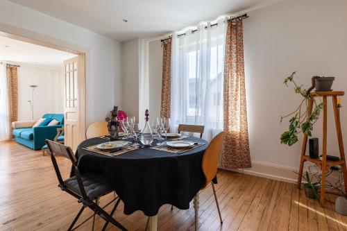 - une table à manger avec une nappe noire et des chaises dans l'établissement Le Seventies - Proche de Montbéliard, à Valentigney
