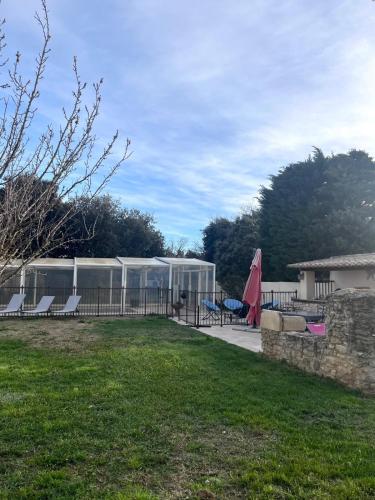 a garden with a tent and chairs in a yard at Maison individuelle Grillon avec wifi in Grillon