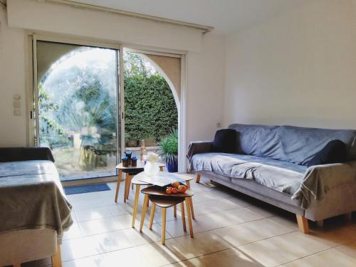 un salon avec un canapé et une grande fenêtre dans l'établissement Maison 115m2 - 400 m de la plage - parking, à Fréjus