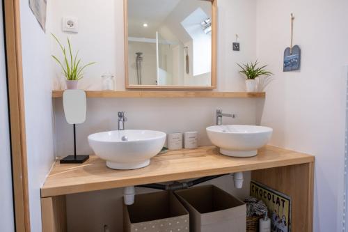 - une salle de bains avec deux lavabos sur un comptoir en bois dans l'établissement La maison aux volets bleus à 300m de la plage, à Locquirec