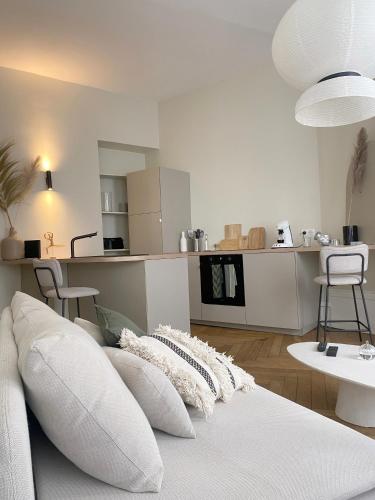 un salon avec un canapé blanc avec des oreillers dans l'établissement Appartement hausmannien au coeur du 7e, à Lyon