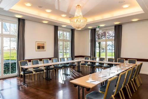 a large room with tables and chairs and windows at Precise Resort Schwielowsee - Apartments in Werder