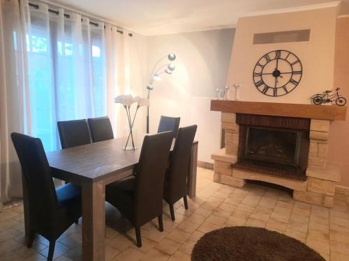 une salle à manger avec une table et une cheminée dans l'établissement Charmante maison sur Auxerre, à Auxerre