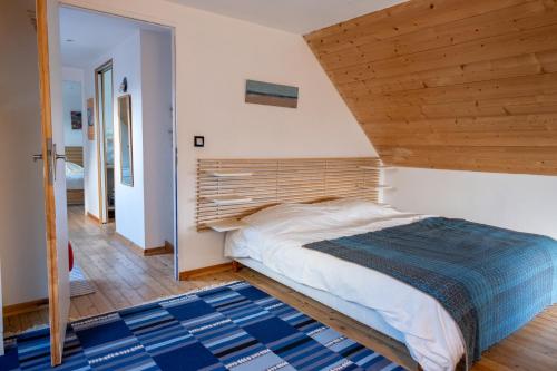 une chambre avec un grand lit avec une tête de lit en bois dans l'établissement La maison aux volets bleus à 300m de la plage, à Locquirec