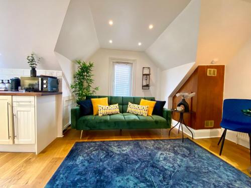 a living room with a green couch and a blue rug at Pinnacle Apartment in Reading