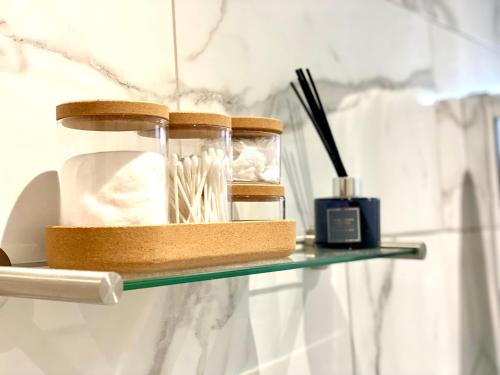 a glass shelf with a bottle and a candle on it at Pinnacle Apartment in Reading