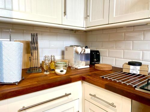 a kitchen with white cabinets and a wooden counter top at Pinnacle Apartment in Reading